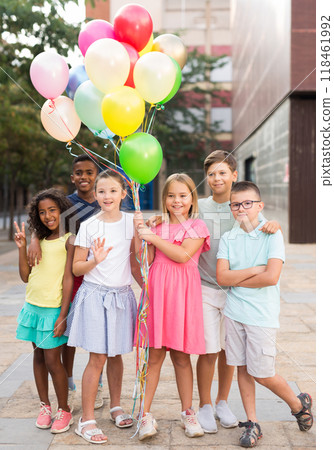 Barefoot kids standing with balloons outdoors Barefoot kids standing with balloons outdoors 118461992
