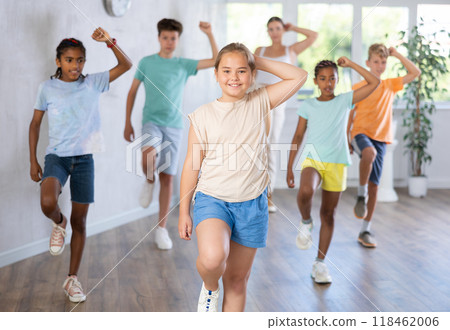 Girl child perform social dance vogue with friends and female teacher in background 118462006