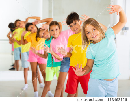Cheerful tweens standing in row one by one learning funny dance Cheerful tweens standing in row one by one learning funny dance 118462126