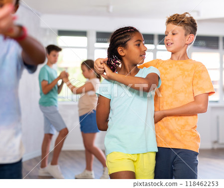Active preteen children practicing Ballroom dances in pairs in training hall 118462253