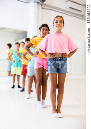 Tween girl with children standing in row one by one in choreography class Tween girl with children standing in row one by one in choreography class 118462292