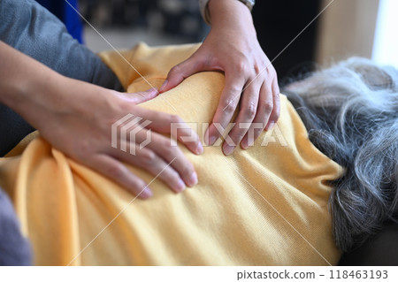 Close up view of physiotherapist massaging back and shoulder blades of mature patient Close up view of physiotherapist massaging back and shoulder blades of mature patient 118463193