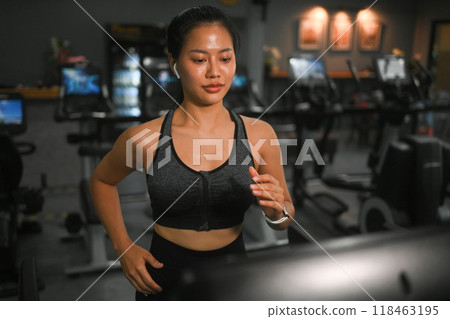Shot of young athletic woman in sportswear running on a treadmill at gym 118463195