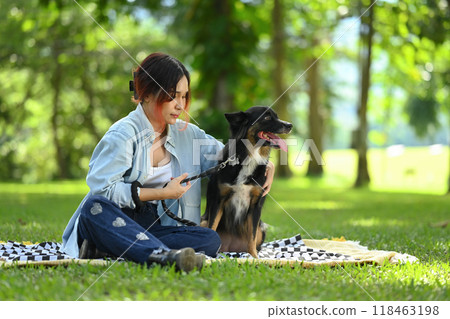 Carefree young woman resting on the grass and embracing her border collie dog with love 118463198