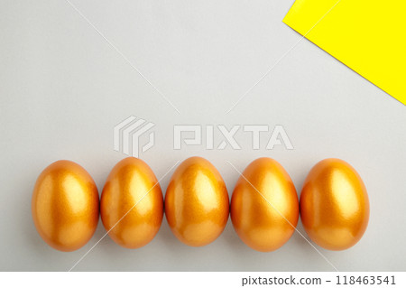 Gold Easter eggs on grey background. Spring concept. Gold Easter eggs on grey background. Spring concept. 118463541