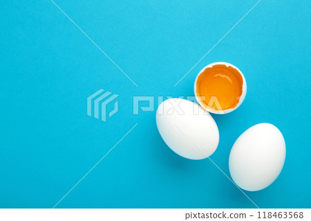 White eggs and egg yolk on the blue background. Easter concept. 118463568
