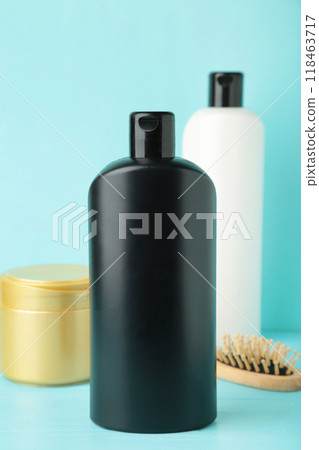 White and black shampoo bottle with comb and hair mask on blue White and black shampoo bottle with comb and hair mask on blue 118463717