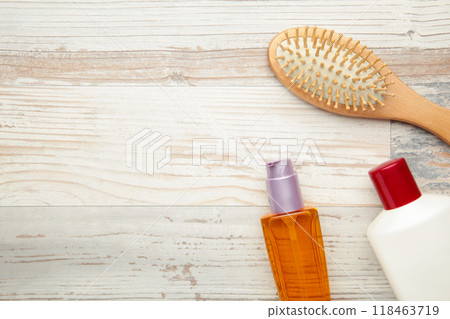 Hair oil, shampoo and hairbrush on light background. Hair care. 118463719