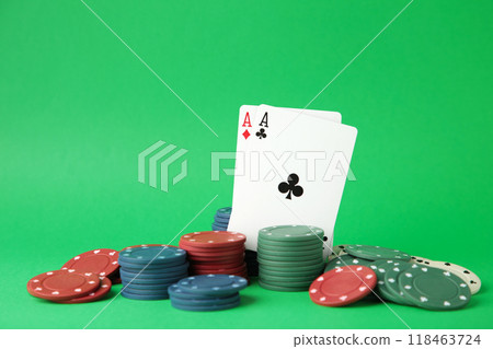 Poker chips and playing cards on green background 118463724