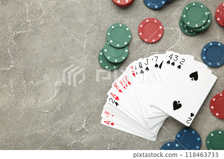 Poker chips and playing cards on grey background 118463733
