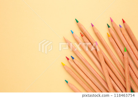 Colored pencils on beige background with copy space. Top view. Colored pencils on beige background with copy space. Top view. 118463754