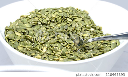 Shelled Pumpkin Seeds on a White Plate - Side View 118463893