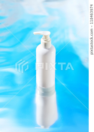 The image featuring a minimalist product shot with a white pump bottle on a bright blue background with subtle white waves, allowing the product to dominate the scene. 118463974
