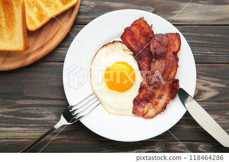 Eggs and bacon for breakfast on brown background. English breakfast Eggs and bacon for breakfast on brown background. English breakfast 118464286