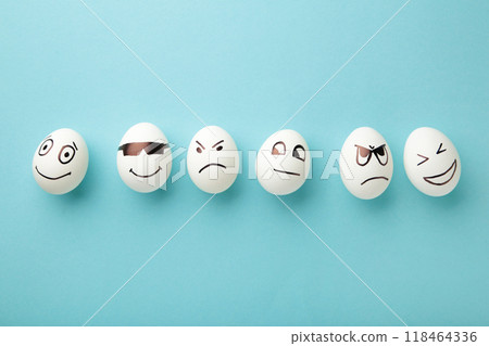 Funny Easter eggs with different emotions on his face on blue background. Easter composition. Funny Easter eggs with different emotions on his face on blue background. Easter composition. 118464336