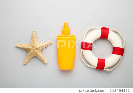 Sun protection bottle with beach accessories on grey background. 118464351