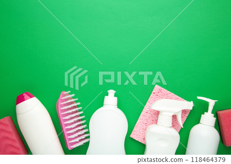 Cleaning Set. Pink and white tools for cleaning. Cleaning agents, spray, rubber gloves on green background. Cleaning Set. Pink and white tools for cleaning. Cleaning agents, spray, rubber gloves on green background. 118464379