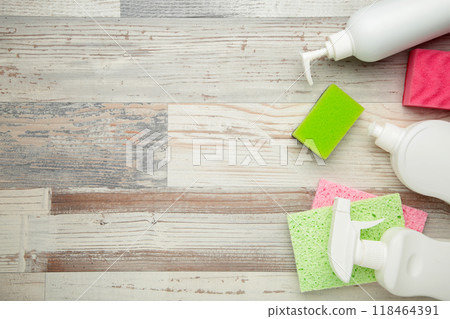 Cleaning Set. Yellow and white tools for cleaning. Cleaning agents, spray, rubber gloves on grey wooden floor background. Cleaning Set. Yellow and white tools for cleaning. Cleaning agents, spray, rubber gloves on grey wooden floor background. 118464391