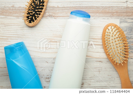 White and blue shampoo bottle with combs on grey background. 118464404