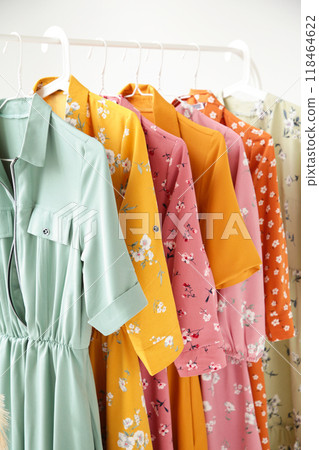 A series of fashion women's dresses on hangers in a white cupboard for summer and spring. 118464622