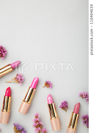 Lipstick with beautiful flowers on grey background with copy space. Vertical photo Lipstick with beautiful flowers on grey background with copy space. Vertical photo 118464639