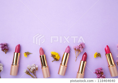 Lipstick with beautiful flowers on purple background 118464640