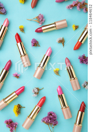 Lipstick with beautiful flowers on blue background with copy space. Vertical photo 118464652
