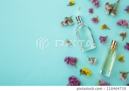 Bottle of perfume with flowers on blue background with copy space Bottle of perfume with flowers on blue background with copy space 118464710