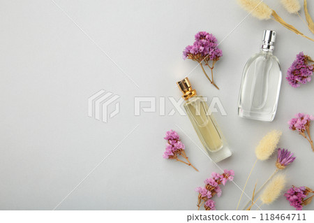 Bottle of perfume with flowers on grey background 118464711