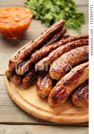 Grilled sausages on wooden board on grey background 118464741
