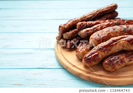 Grilled sausages on wooden board on blue background with copy space Grilled sausages on wooden board on blue background with copy space 118464743