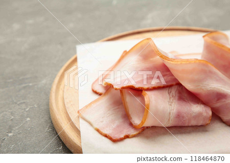 Fresh raw sliced bacon on the wooden cutting board on grey. Fresh raw sliced bacon on the wooden cutting board on grey. 118464870