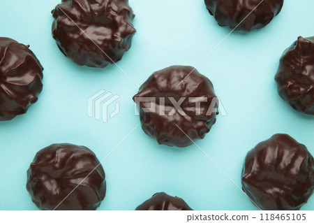Chocolate covered marshmallows on blue background. Minimalism Chocolate covered marshmallows on blue background. Minimalism 118465105