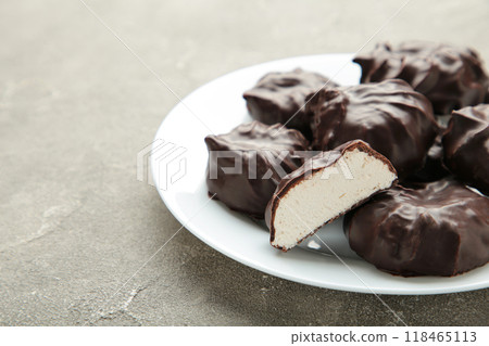 Chocolate covered marshmallows on plate on grey background. 118465113