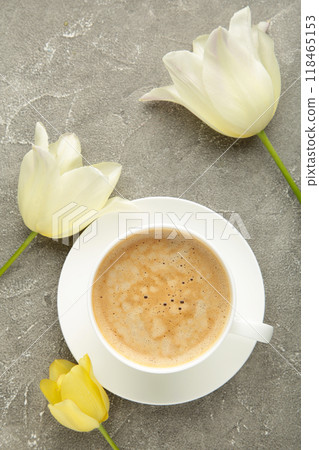 Cup of coffee with white tulips on grey background. Vertical photo Cup of coffee with white tulips on grey background. Vertical photo 118465153