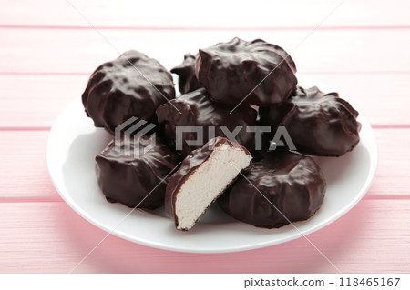 Chocolate covered marshmallows on plate on pink background. Chocolate covered marshmallows on plate on pink background. 118465167