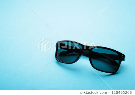 Stylish black sunglasses on a blue background with copy space Stylish black sunglasses on a blue background with copy space 118465266
