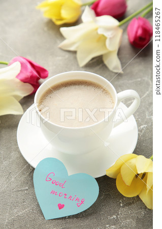 Coffee mug with tulip flowers and notes good morning on grey background, breakfast on Mothers day or Womens day. Vertical photo 118465267