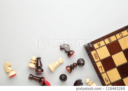 Symbol of competition. Chess board and chess figures on grey background top view copy space 118465268