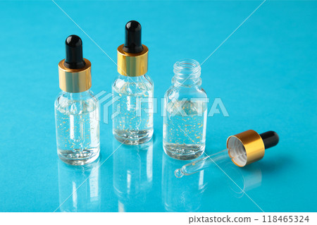 A glass bottles with a pipette with oil, serum on blue background with copy space. Flatlay 118465324