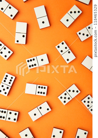 Playing dominoes on a orange table. Domino effect Playing dominoes on a orange table. Domino effect 118465329