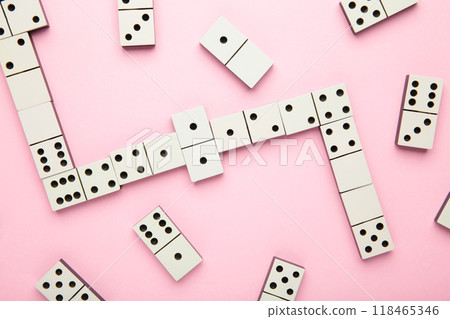 Playing dominoes on a pink background . Domino effect Playing dominoes on a pink background . Domino effect 118465346