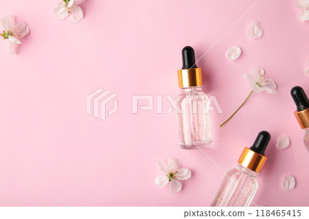 Beauty cosmetic skincare oil in bottle. Products with flower on pink background. Top view 118465415