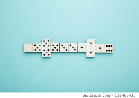 Playing dominoes on a blue background . Domino effect Playing dominoes on a blue background . Domino effect 118465435