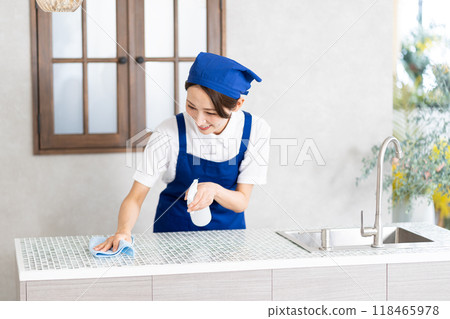 A woman from a housekeeping service cleaning the kitchen A woman from a housekeeping service cleaning the kitchen 118465978