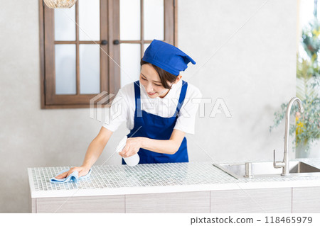 A woman from a housekeeping service cleaning the kitchen A woman from a housekeeping service cleaning the kitchen 118465979