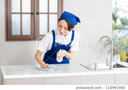 A woman from a housekeeping service cleaning the kitchen A woman from a housekeeping service cleaning the kitchen 118465980