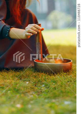 singing bowl played by therapist on green outdoors 118466728