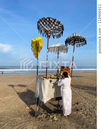 Balinese woman performing traditional ritual of offering to gods 118466911