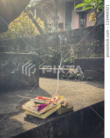 Traditional balinese offerings to gods in Bali with flowers and aromatic sticks 118466921